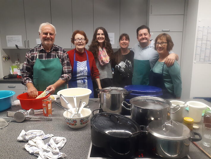 Frauen und Männer beim kochen in einer Küche